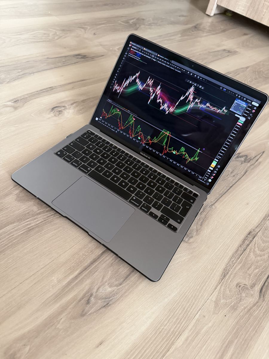 Laptop z wykresem bitcoina na drewnianej podłodze